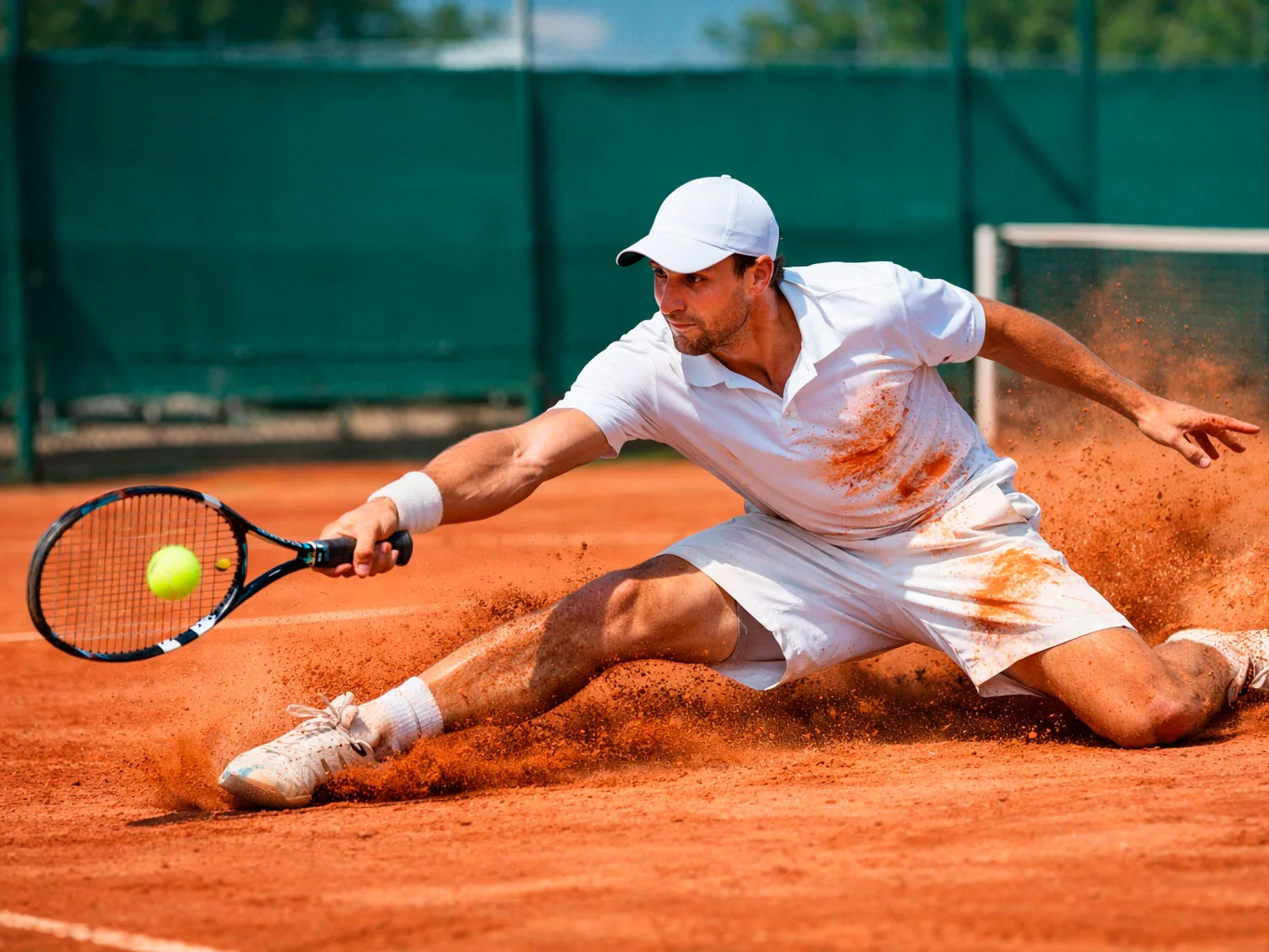 Joueur de tennis en pleine glissade sur terre battue