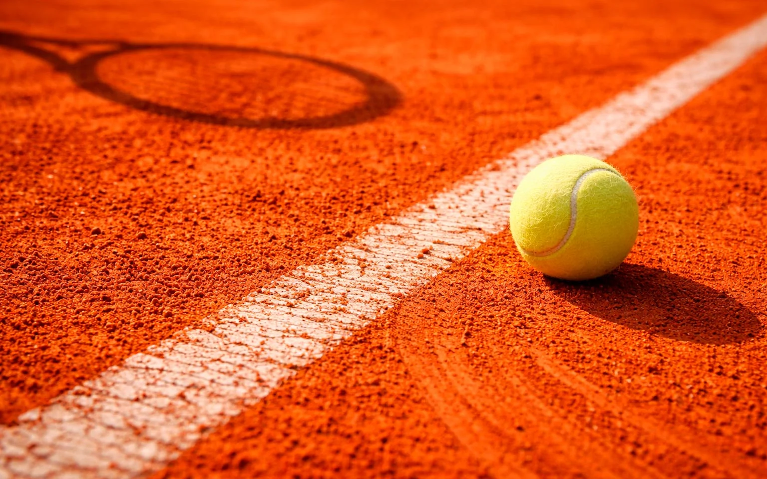 Gros plan sur la surface de terre battue ocre avec les lignes blanches du court de tennis